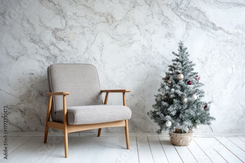 Armchair and decorated Christmas tree stand before a textured marble wall.