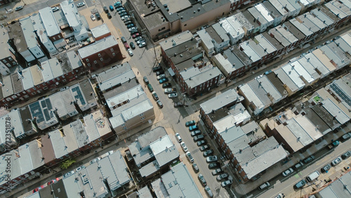 Angled street convergence near S 13th St and Shunk St highlights intersecting corridors, uniform rowhome massing. Light colored roofs, subtle material shifts, soft afternoon diffusion Philly, PA