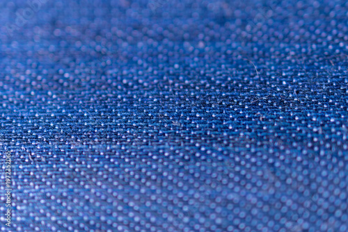 Low angle macro perspective of textured blue woven fabric showcasing clean grid patterns for a minimalist industrial design.