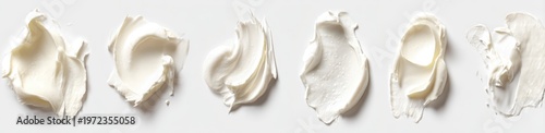 Six Swirls of Creamy White Cosmetic Product on a White Background.