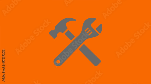 Tools of the trade - Hammer and wrench crossed on orange background.