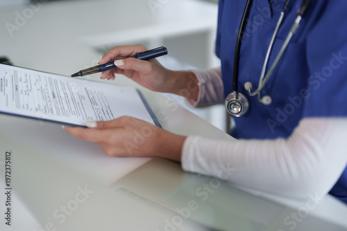 Adult healthcare professional hands reviewing patient medical document administrative paperwork clinic hospital office health data management