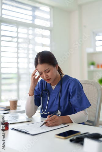 Obraz na plátně Asian adult healthcare worker experiencing work related stress burnout headache
