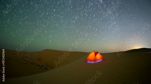 Stunning 4k timelapse of the star tail motion in the sky above desert sand dune in a remote wilderness location.