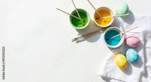 Easter egg painting setup with colorful paints and brushes with still life with white cloth with easter tradition with holiday preparation with hobby supplies