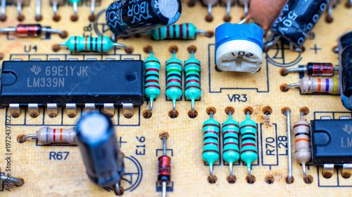 Bilde på lerret Close-up of a vintage yellow printed circuit board featuring various through-hole components like resistors, capacitors, and integrated circuit chips from legacy electronic equipment