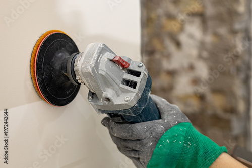 Wall grinding tool in hand during working process