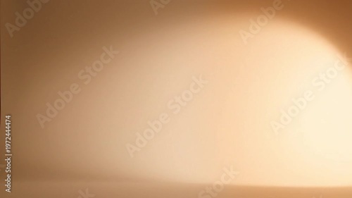 Warmly lit abstract background with a smooth gradient transitioning from dark to light beige tones.