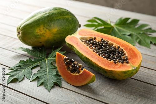 Freshly sliced papaya on a wooden table with green leaves in the background, showcasing its vibrant color