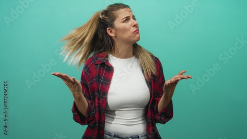 Photography Woman in red plaid shirt raises palms in a shrugging gesture with expressive face in studio; exasperation doubt