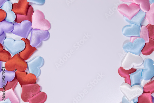 Multicolored hearts lie on a white background. Space for text.