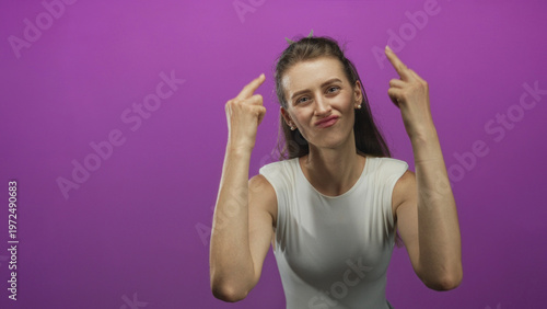 Quadro em tela Young caucasian woman shows both middle fingers to camera against purple studio wall; defiance rebellion attitude