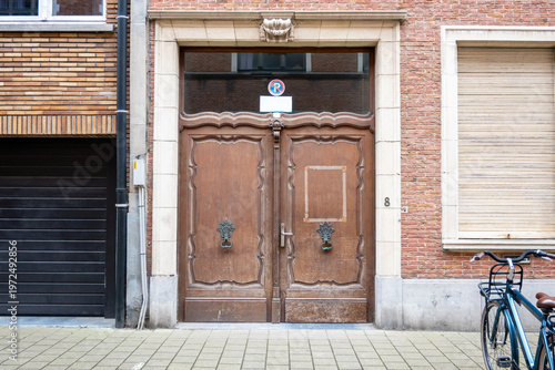 Old wood gate door in the ancient estate with two windows, garage and bike.