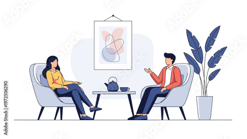Two people sitting in comfortable armchairs having a relaxed conversation over tea in a modern room with a plant and artwork.