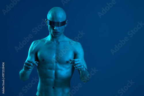Athletic man in futuristic sunglasses, showcasing a unique style and bold vibe, captured against a blue background, exuding confidence and strength.