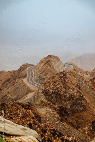 Foto Aerial view of switchback mountain road with sharp hairpin bends steep rock formation