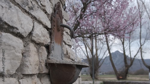 Bottom view of a fountain with running water and a stone wall, Rocchetta a Volturno, Molise, Italy