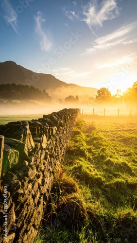 Serene Sunset Over Misty Meadow with Stone Wall in Background