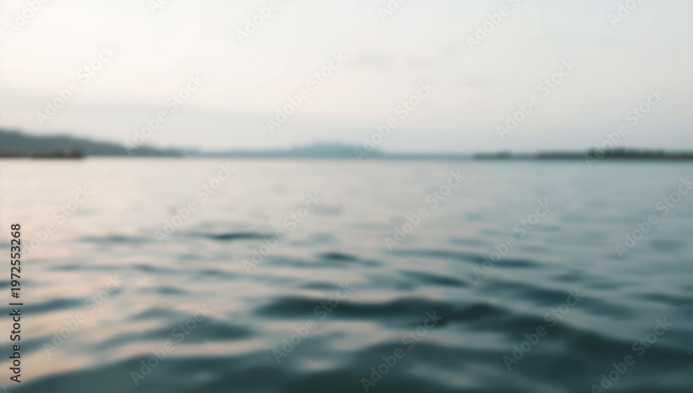 Obraz premium Calm Water Body with Gentle Waves Under Overcast Sky in Natural Outdoor Setting