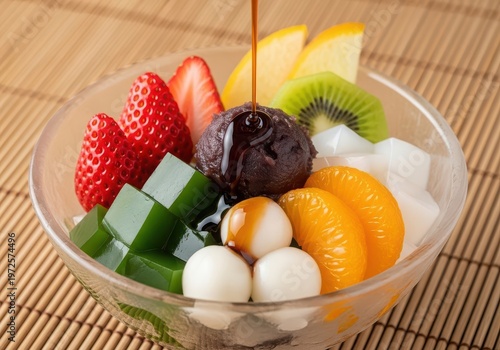 Japanese dessert anmitsu with red bean paste, mochi, fresh fruits, and agar jelly drizzled with kuromitsu syrup