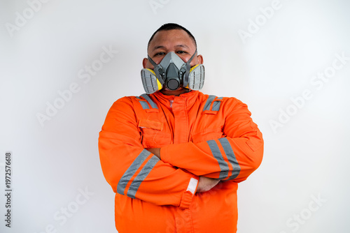 Worker in orange protective suit and respirator mask, confident pose