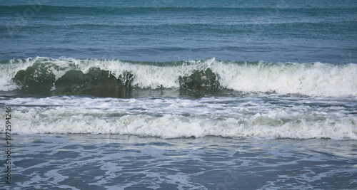 A high-quality collection of ocean waves crashing on the shore with white sea foam and splashing water against a clear blue sky, perfect for coastal tourism, summer vacation, and natural background.