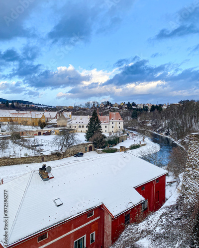 The panorama view of white snowy and fairy tale village and houses covered by snow in winter in Cesky Krumlov, UNESCO world heritage site in the South Bohemian region, Czech republic, Czechia 