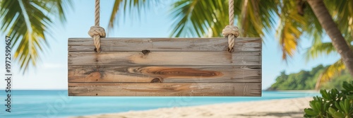 Empty weathered wooden sign hanging from rope on tropical beach with palm trees and ocean empty sign