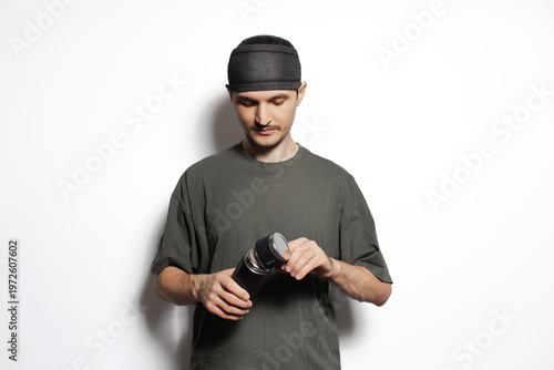 Young man holding thermos in hands isolated on white background.Young man holding thermos in hands isolated on white background.