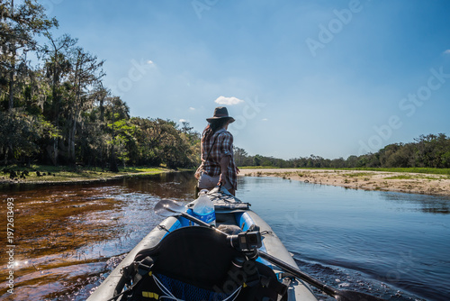 A woman is sitting in a canoe on a river