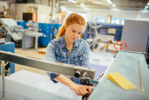Photos Female technician operating printing machine in factory
