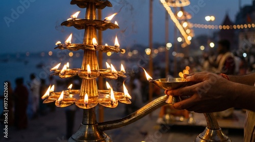 Ganga aarti ritual with diya lamp at river ghat evening spiritual hindu worship ceremony glowing lights cultural tradition scene for travel and festival use