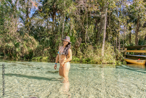A woman in a bikini is standing in a lake