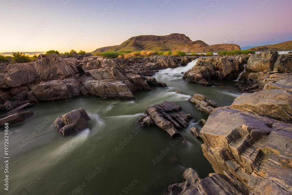 Obraz premium Orange river flowing in arid canyon near Augrabies Falls with slow motion to show water movement