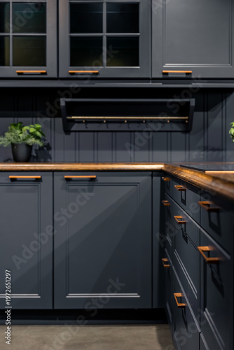 Modern blue kitchen cabinets with wooden countertop. Elegant home interior with copper handles.