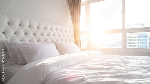 Bright bedroom featuring luxurious white tufted headboard, soft bedding, and morning sun streaming through window