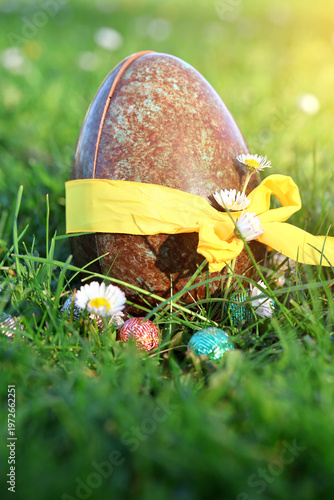 PARIS, FRANCE - APRIL 4, 2026: A large chocolate Easter egg hidden in the green grass. The Easter egg hunt tradition
