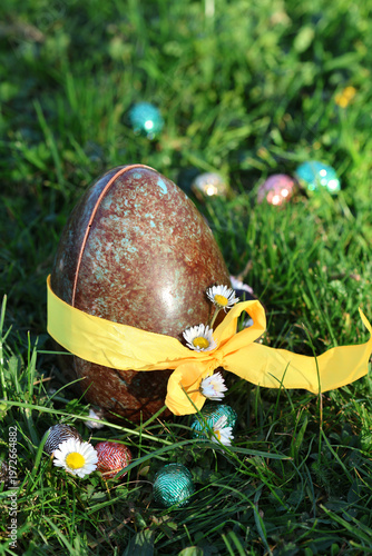 PARIS, FRANCE - APRIL 4, 2026: A large chocolate Easter egg hidden in the green grass. The Easter egg hunt tradition
