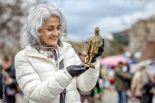 Tablou pe pânză Woman finding a bronze figurine at a flea market
