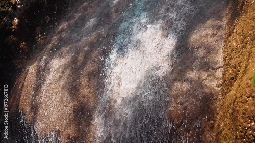 Closeup of water flowing over textured rock surface creating natural abstract pattern and motion, Minimal cascade detail with wet stone and dynamic water splash, slow motion 4k