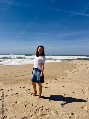 A summer stroll along the Atlantic Ocean beach. The model is a 50-year-old woman.