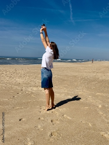 A summer stroll along the Atlantic Ocean beach. The model is a 50-year-old woman.