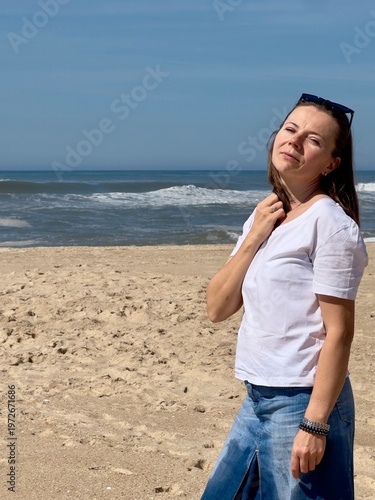 A summer stroll along the Atlantic Ocean beach. The model is a 50-year-old woman.