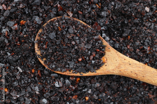 Macro Shot of Dried Isot Pepper Flakes in a Wooden Spoon Isolated on White Background - Turkish Chili