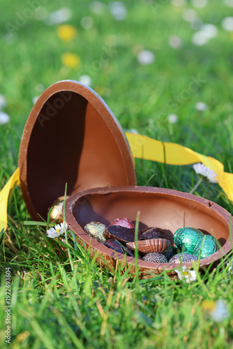 PARIS, FRANCE - APRIL 4, 2026: A large chocolate Easter egg hidden in the green grass. The Easter egg hunt tradition
