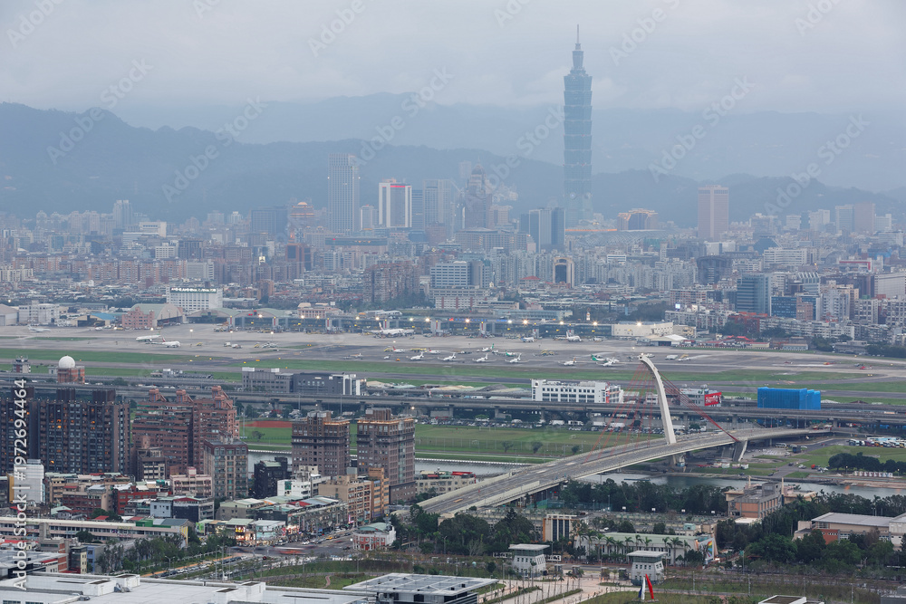 Fototapeta premium Panoramic aerial view of busy Taipei city, Keelung river, Dazhi Bridge, Songshan Airport and Taipei 101 at dusk ~ A romantic evening in Taipei Taiwan, with beautiful blue gloomy mood in the sky