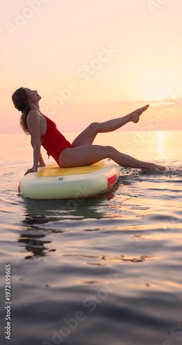 Young woman walking on sup board by the sea during summer vacation