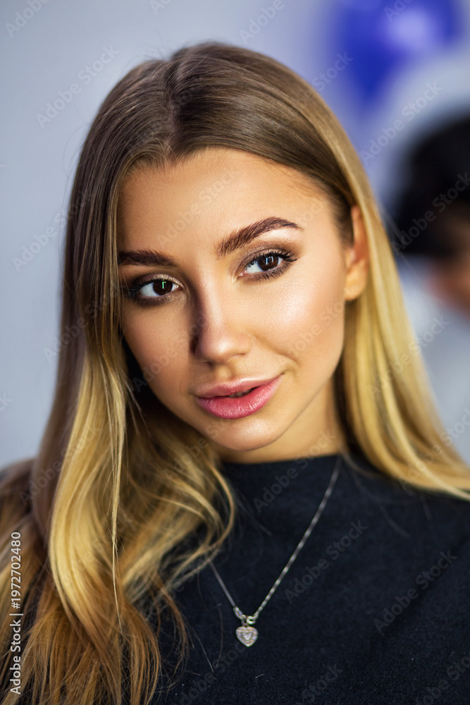 Naklejka premium Makeup artist applying cosmetics to woman sitting at dressing table with mirror and beauty products in modern salon
