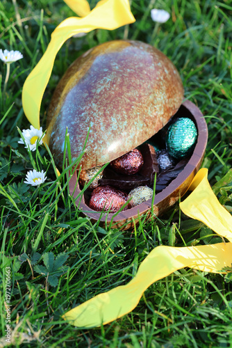 PARIS, FRANCE - APRIL 4, 2026: A large chocolate Easter egg hidden in the green grass. The Easter egg hunt tradition
