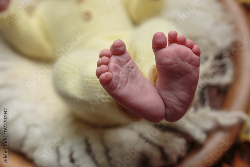 Tiny feet of a newborn in yellow